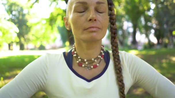 4K夏の公園の女性は ヨガの瞑想演習を行います ベリーダンス 胃の使用 スライダーショット ゆっくりとした動き — ストック動画