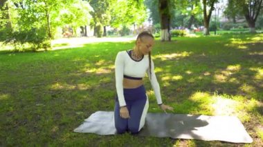4k. Yaz şehir parkında yetişkin yoga kadın meditasyon egzersizleri yapmak. Asana, sabit atış