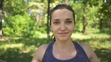 Trx spor takımı. Şehir parkında açık havada egzersiz yapan genç kadının yüzü. Yavaş çekim 