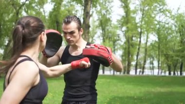 Yavaş hareket. Şehir Parkı alanında kadın ve adam eğitim boks süreci açık. Sabit atış