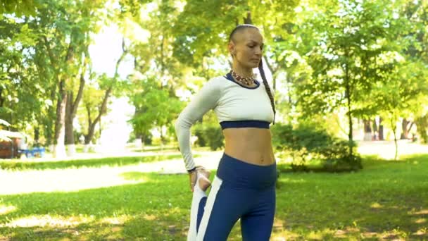 市内の日当たりの良い公園で魅力的な大人の女性のヨガ瞑想演習 アーサナ — ストック動画