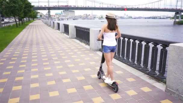 Hedendaagse Meisje Rijden Elektrische Scooter Stadgebied Stabiel Schot Achteraanzicht — Stockvideo