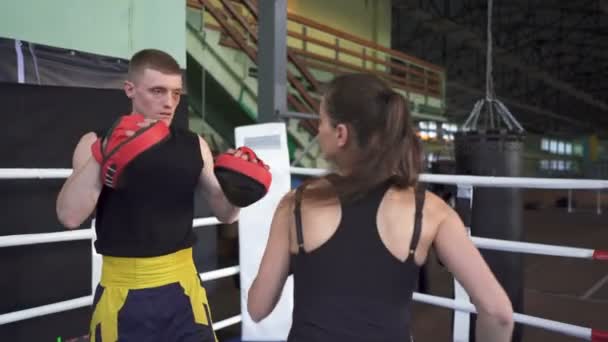 プロの男ボクサーでお辞儀する女性のトレーニング 手に吹く — ストック動画