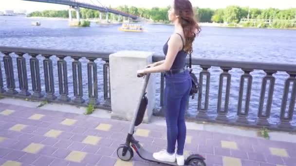 Menina Bonita Montando Scooter Elétrico Área Cidade Perto Rio Steady — Vídeo de Stock