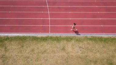 4k . Hava. Genç sportif kadın stadyumda çalıştırmak, üst görünümü, Sağlıklı yaşam
