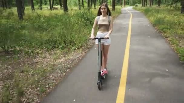 Zwolnij Trochę Młoda Seksowna Dziewczyna Jeździ Skuterze Elektrycznym Parku Miejskim — Wideo stockowe