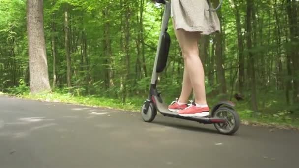 慢动作 年轻性感的女孩骑电动车在城市公园区 背景色 — 图库视频影像