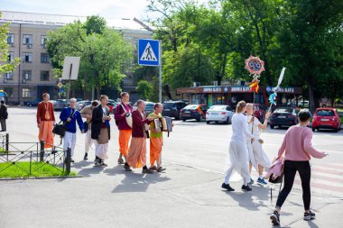 Ukrayna, Kyiv - 5 Haziran 2020: Krishnaites cadde boyunca yürür, şarkı söyler, davul çalar ve dans eder. Dindar Ukraynalı Krishnaist - Hare Krishna takipçileri, geleneksel turuncu ve pembe dhoti kıyafetleri içinde.