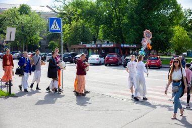 Ukrayna, Kyiv - 5 Haziran 2020: Krishnaites cadde boyunca yürür, şarkı söyler, davul çalar ve dans eder. Dindar Ukraynalı Krishnaist - Hare Krishna takipçileri, geleneksel turuncu ve pembe dhoti kıyafetleri içinde.