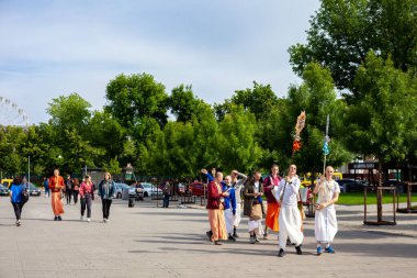 Ukrayna, Kyiv - 5 Haziran 2020: Krishnaites cadde boyunca yürür, şarkı söyler, davul çalar ve dans eder. Dindar Ukraynalı Krishnaist - Hare Krishna takipçileri, geleneksel turuncu ve pembe dhoti kıyafetleri içinde.