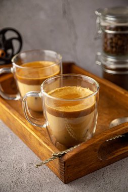 Dalgona kahvesi. Tahta arka planda Kore kahvesi. Şeker ve sıcak suyla çırpılmış kahve ya da espresso tozu. Buzlu dalgona kahve konsepti..
