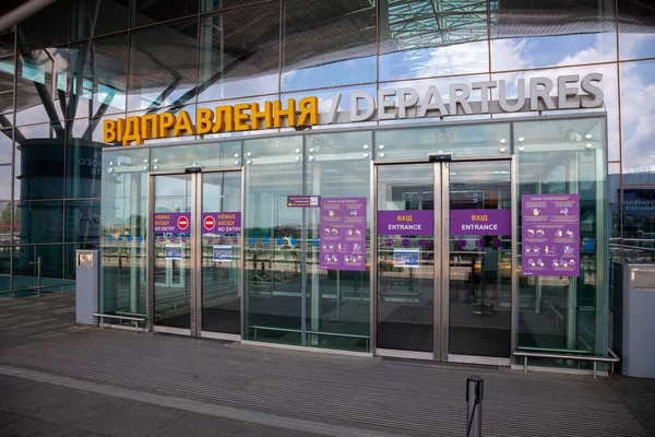 Boryspil, Ukrayna - 22 Haziran 2020: Kyiv 'deki D terminalinin ana girişi. Ayrılışları imzala. Koronavirüs salgını sırasında maske takıp mesafeyi korumakla ilgili bir poster..
