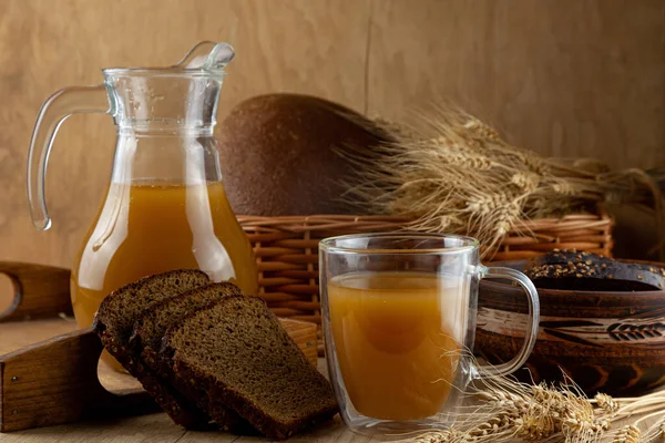 Ev yapımı ekmek kasesi. Yaz karbonatlı meşrubat. Ahşap bir masada cam ve sürahi. Kara Denizaşırı Çavdar Ekmeği - İçmek İçin Malzemeler.