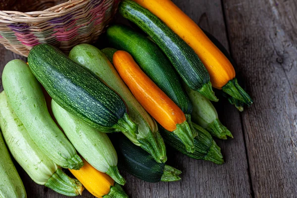 Una serie di zucchine multicolori giallo, verde, bianco, arancione sul tavolo primo piano. Esperienza alimentare. Zucca appena raccolta, zucca estiva tagliata. Ho raccolto zucchine verdi. Natura morta in cucina. — Foto Stock