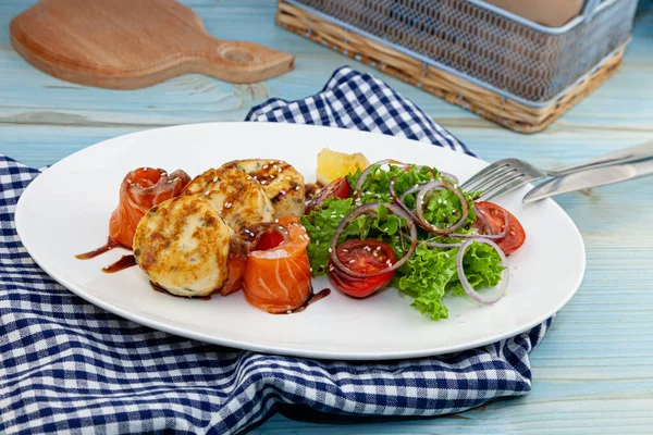 Fish cakes with salad, tomatoes and red onions in a restaurant on a white plate. Red salmon fish. Fish menu. Close-up. Healthy Omega-3 food. — Stock Image Fish Cakes Salad Tomatoes Red Onions Restaurant White Plate Red Royalty Free Stock Images
