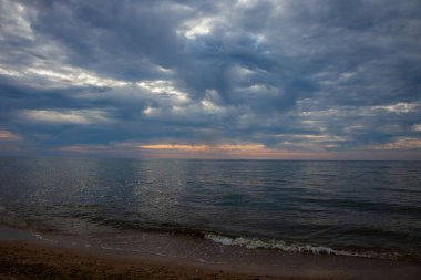 Deniz Burnu. Dalgalar ve sörf. Denizde gün batımı ve şafak. Okyanusta sakin ol. Güneşle aydınlanan güzel gökyüzü ve bulutlar. Doğal arka plan. Yaz zamanı..