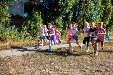 Ukrayna, Kyiv - 11 Ağustos 2020: Kızlar sokakta koşuyor. Açık hava sporu. Çocuklarda fiziksel aktivite.