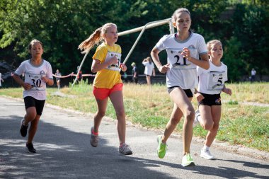 Ukrayna, Kyiv - 11 Ağustos 2020: Kızlar sokakta koşuyor. Açık hava sporu. Çocuklarda fiziksel aktivite.