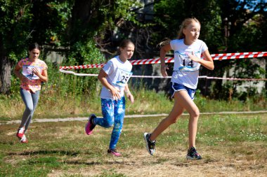 Ukrayna, Kyiv - 11 Ağustos 2020: Kızlar sokakta koşuyor. Açık hava sporu. Çocuklarda fiziksel aktivite.