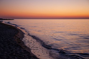 Deniz Burnu. Dalgalar ve sörf. Denizde gün batımı ve şafak. Okyanusta sakin ol. Güneşle aydınlanan güzel gökyüzü ve bulutlar. Doğal arkaplan.