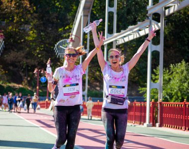 Ukrayna, Kiev - 12 Eylül 2020: Koşucular şehirde koşuyor. Sokak yarışması holi renk yarışı. Renkli koşu. Hint boyasıyla boyanmış yüzler ve giysiler. Yüzlerinde gülümseme.