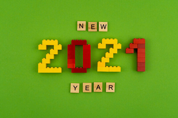Фраза "Новый 2021 год" выстлана деревянными буквами на зеленом фоне. Рисунки из окна конструктора. Открытка на месте для текста. Флэтли.