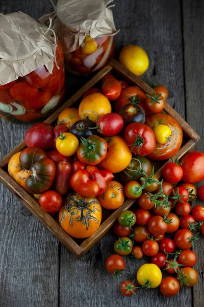 Pomidory o różnych odmianach i kolorach widok z góry. Układ na drewnianym tle. Jedzenie. Pomidor w plasterkach, składniki sałatki. Miejsce na tekst. Żółta i czerwona wiśnia. Przestrzeń kopiowania. — Zdjęcie stockowe