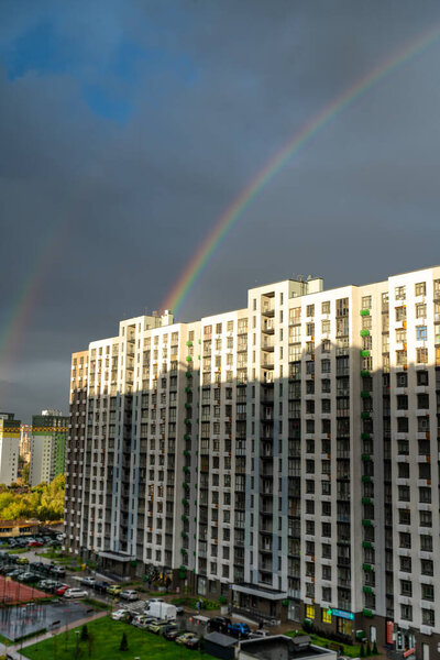 Rainbow over a high-rise building. Multi-apartment residential building. Housing area