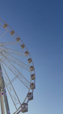 Dönme dolap dönüyor. Mavi gökyüzü uzayı taklit ediyor. Yaz