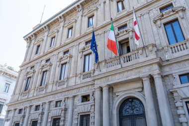 Banca Commerciale Italiana Bankası Milan caddesindeki duvar cephesinde. İtalya ve Avrupa Birliği bayrağı. İtalya, Milan mimarisi