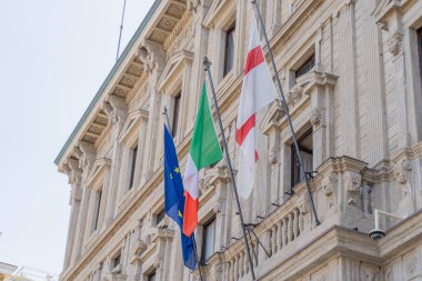 İtalya ve Avrupa Birliği bayrağı. İtalya, Milan. Eski balkon mimarisi Banca Ticari İtalyan sokak duvar cephesi.