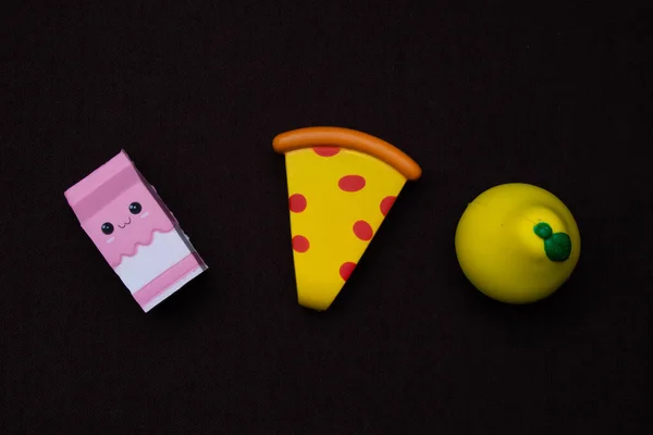 Oyuncak plastik meyve ve yiyecek siyah arka planda izole edilmiş. Çocuk mutfağı için oyuncaklar