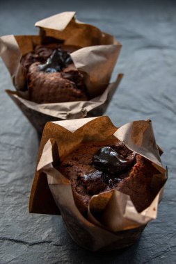 Koyu renkli bir tahtanın üzerinde çikolatalı kek resmi.