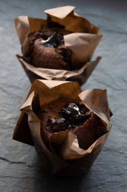 Koyu renkli bir tahtanın üzerinde çikolatalı kek resmi.