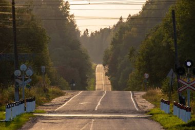 Güneşli bir gün batımına karşı bir akşam yolu. Peyzaj