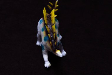 Fotoğraf, arka planda oyuncak bir bebek dinozor. Plastik oyuncak.