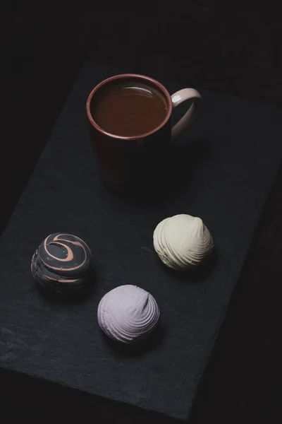 Sabah kahvaltısı, kahve, tatlı marşmelov ve koyu arkaplanda tiramisu..