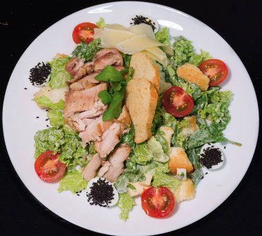 Siyah arka planda Sezar salata tabağı üst