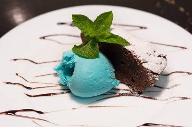 Mavi dondurma ve çikolata kek beyaz plaka üzerinde