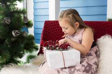 Noel ruh. Küçük kız bir paket Noel'de paketini açmak