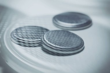 beyaz zemin üzerine gümüş düğme pili