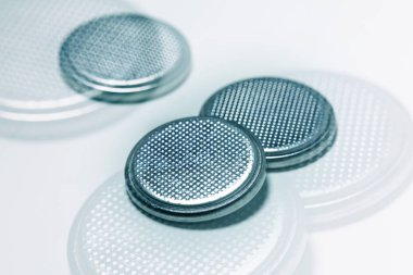 beyaz zemin üzerine gümüş düğme pili