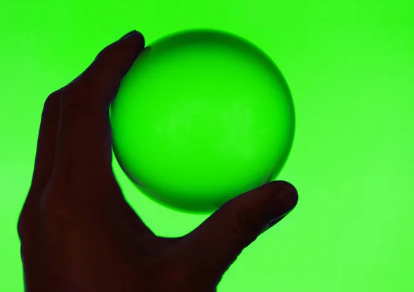 Handen Håller Kristallkula Med Grön Bakgrund — Stockfoto