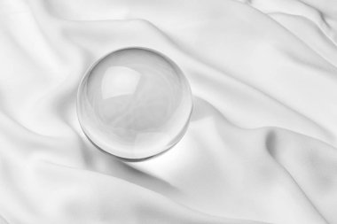 Beyaz arka planlı, şeffaf kristal top yakın çekim.