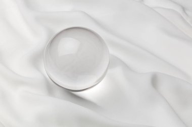 Beyaz arka planlı, şeffaf kristal top yakın çekim.