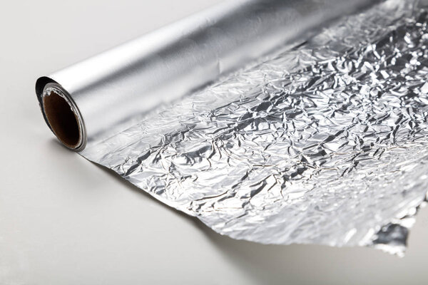 Aluminum foil roll on the white background, close up.