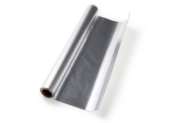 Beyaz zemin üzerine alüminyum folyo rulo yakın çekim.