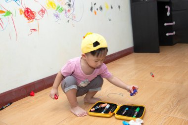  Duvarında boya kalemi renginde çizim yapan küçük bebek.