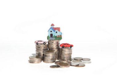 Mülkiyet ve finansal konsept olarak kullanılan küçük renkli ev ve araba yığınları