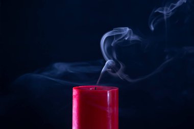 Siyah arkaplanda beyaz dumanlı kırmızı mum 